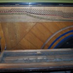 Pianino w trakcie rozbierania, widok na struny oraz półkę klawiaturową