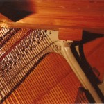 fragment płyty rezonansowej ramy żeliwnej i strun pianina Fricke