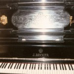 pianino J. Becker widok od przodu widoczna klawiatura i nazwa producenta na pokrywie klawiatury