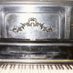 pianino J. M. Kamieniecki widok od przodu na klawiaturę oraz zdobienie pokrywy mechanizmu